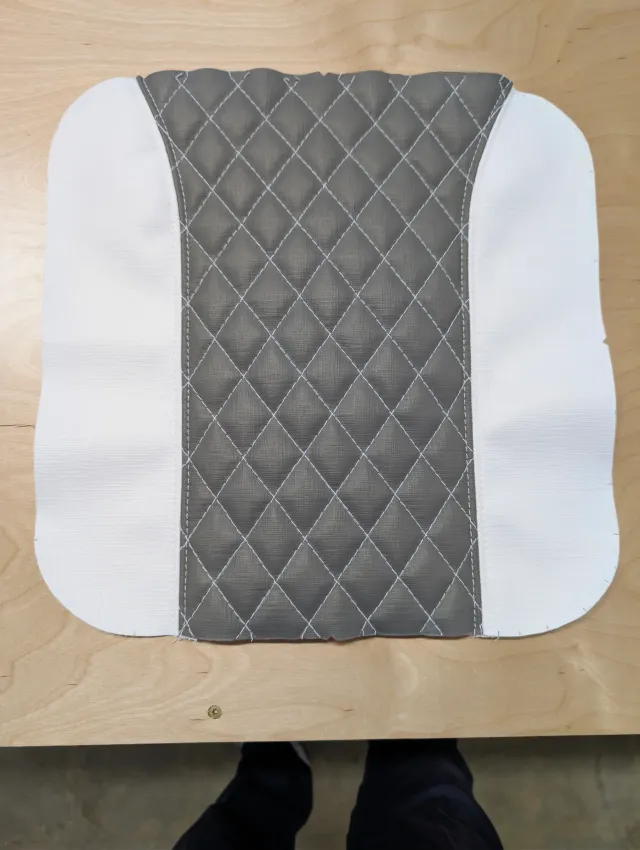 A quilted charcoal centre panel sewn between two white side panels, flat on the bench.