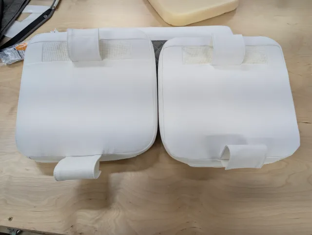 The backs of two new cushions, with fabric strap tabs and mesh vent panels.