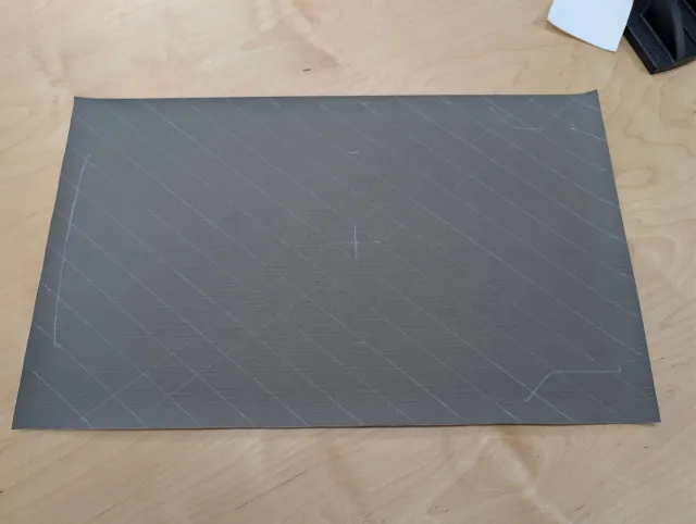 A charcoal panel marked with a diagonal grid and a centre cross.