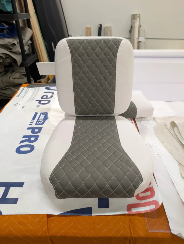 A new seat back cushion standing on its seat bottom, charcoal quilting on white.