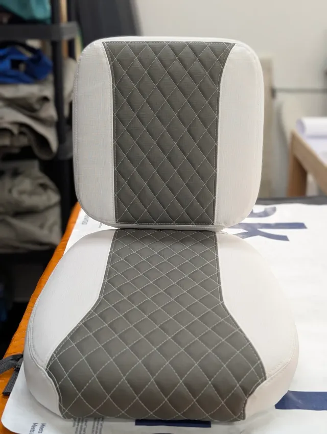Close-up of a seat back and bottom with diamond quilting stitched in white thread.