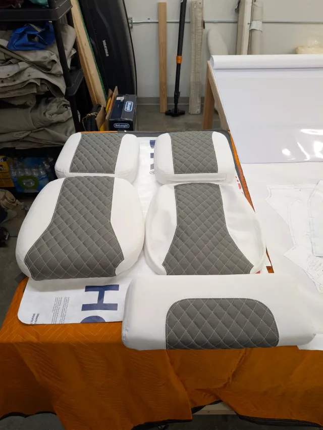 Five new cushions laid out on a moving blanket: two seat bottoms, two backs and a bolster.
