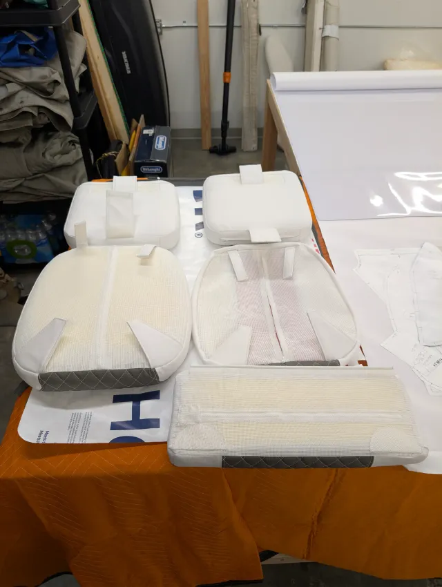 The reverse of the same cushions: white fabric backs, mesh panels and strap tabs.