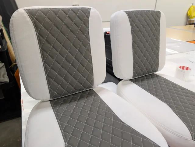 Two new seat backs over their seat bottoms, charcoal quilted centres on white.