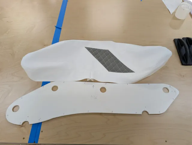 A white cover with a diagonal charcoal panel lying above its paper pattern with cutouts.