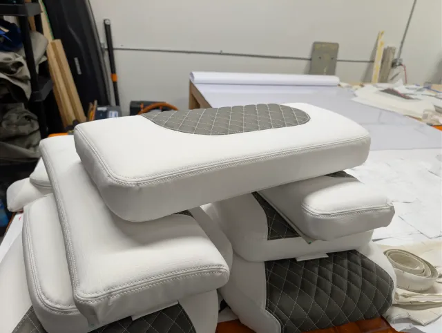A stack of new cushions with a quilted bolster on top.