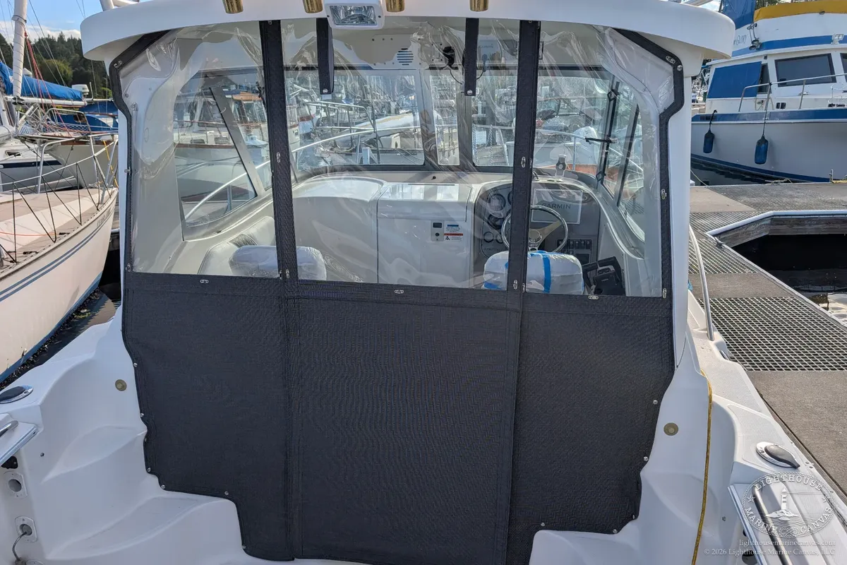 The new aft enclosure on the boat, charcoal lower panels and clear windows, with vertical straps between the sections.