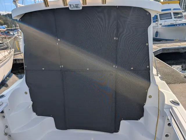 The aft of the cockpit closed off by dark panels with snaps, seen from the dock.