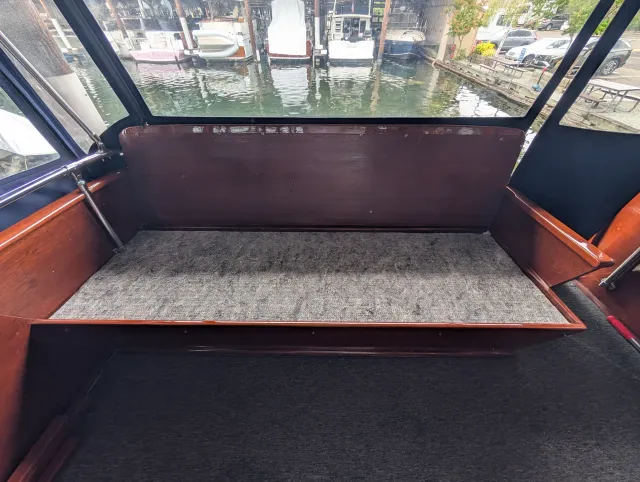 The bare settee with a grey underlayment pad cut to the shape of its seat.