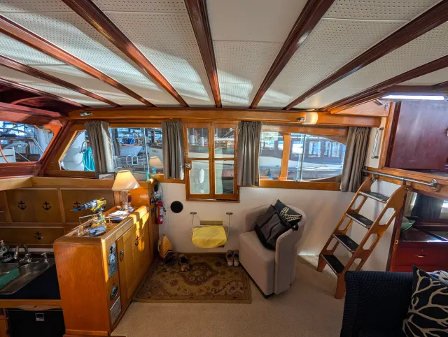 The main cabin, varnished wood and windows all round, curtains hanging on their new track.