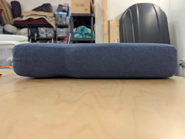 A finished cushion side-on on the bench, its top crowned by the batting beneath.