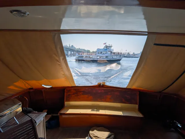 The new clear vinyl window in the aft deck cover, seen from inside, with a passenger ferry passing astern.