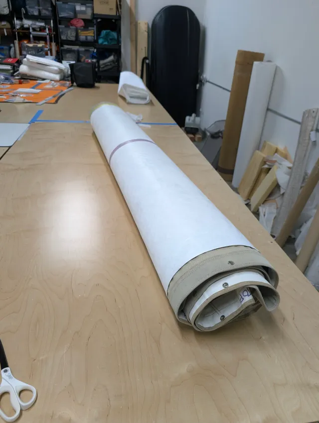 The modified cover with protective paper covering the new vinyl window, on the cutting table.