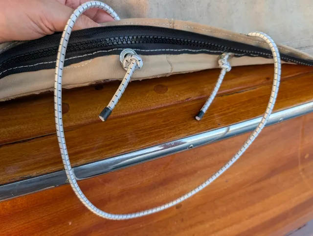 The cover's zippered edge with shock cord loops over the rail.
